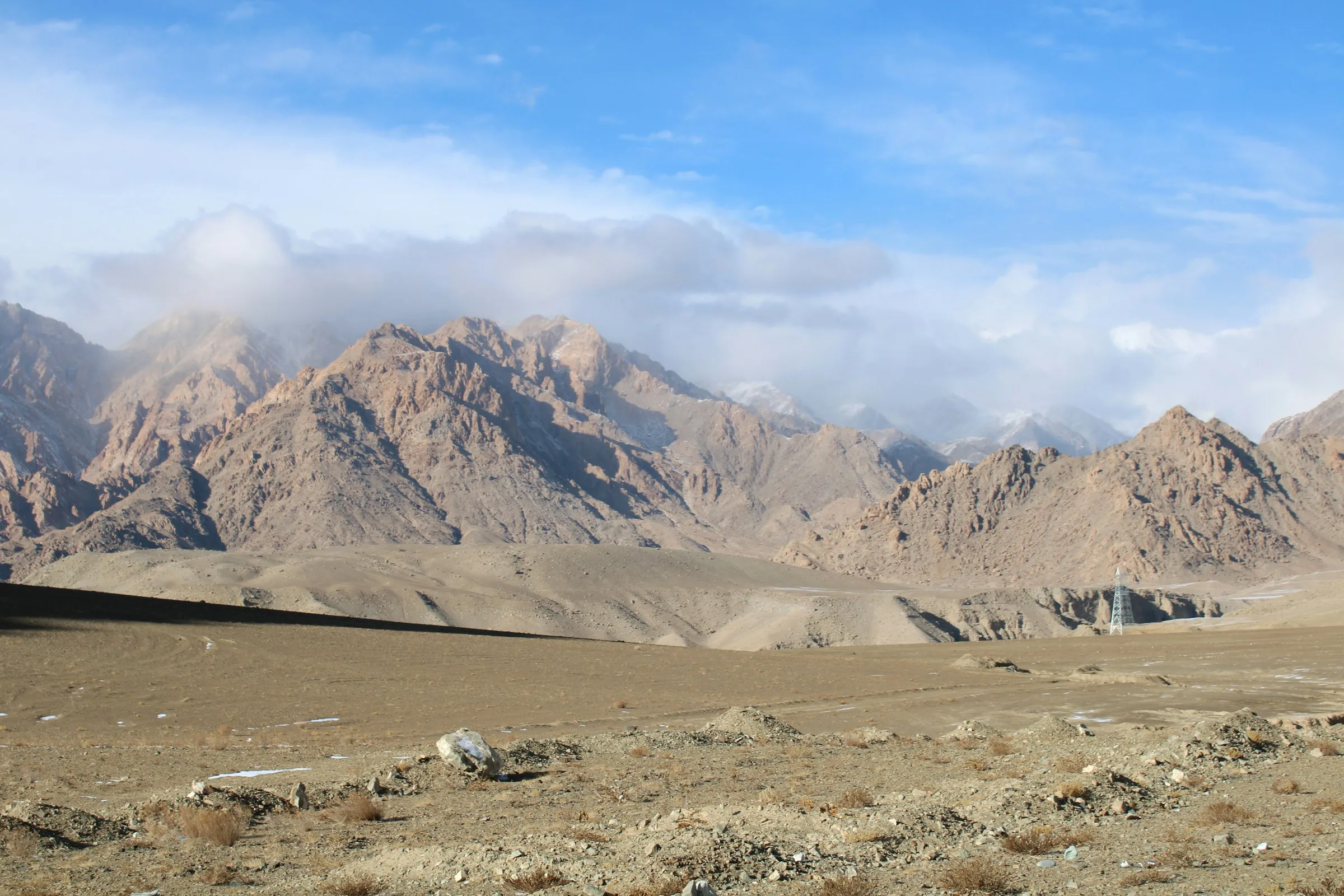 Clouds drifting above the ochre mountains and open plateau of Ladakh